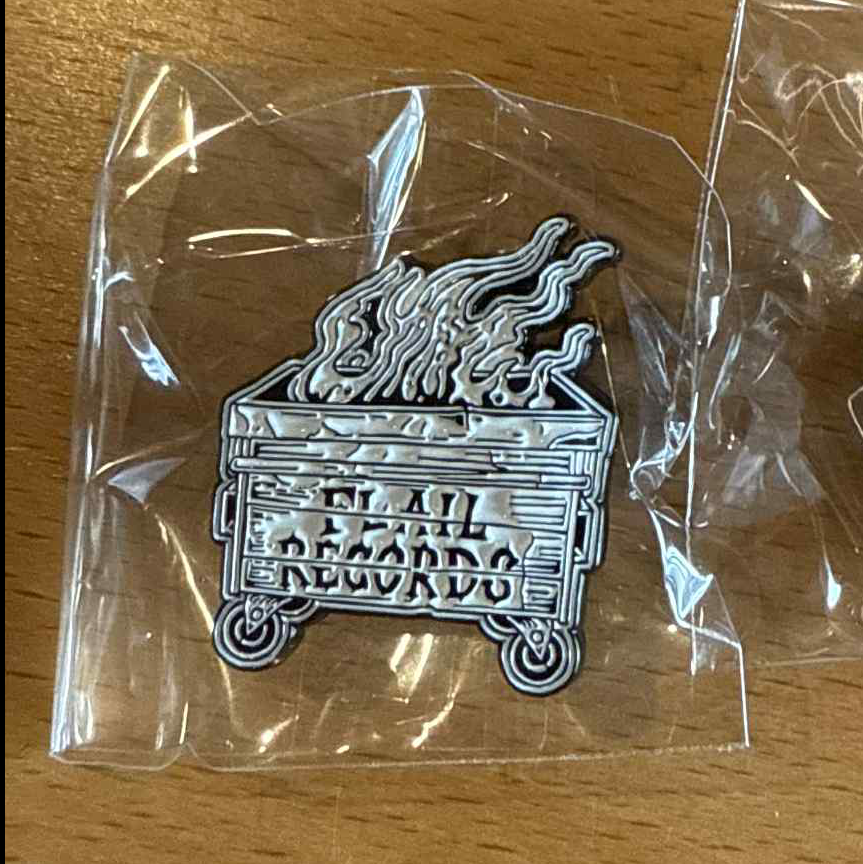 Metal  badge with 'Fail Records' text on a flaming dumpster.